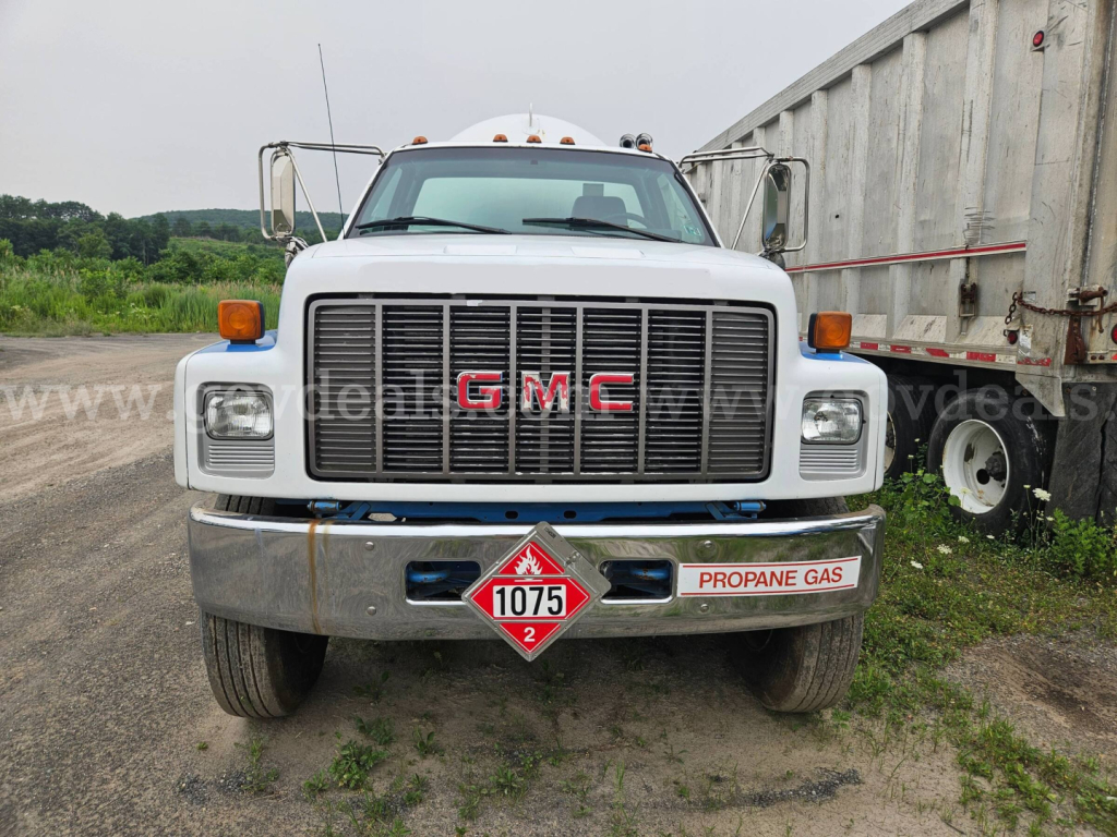 GMC front view of tanker truck showing grille with red GMC letters and propylene gas placard 1075 on bumper