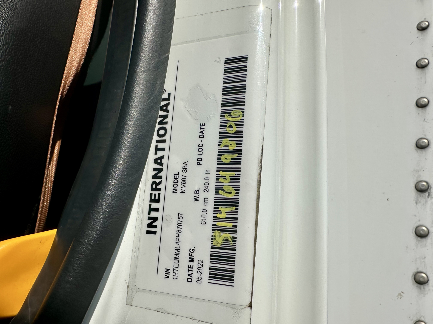 International MV607 VIN plate visible on door frame with model, VIN, date, and color/option codes.