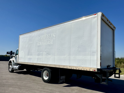 Box truck side view showing RockParts Dealase faded logo on a silver cargo box and rear cap, International MV607 in a parking lot.