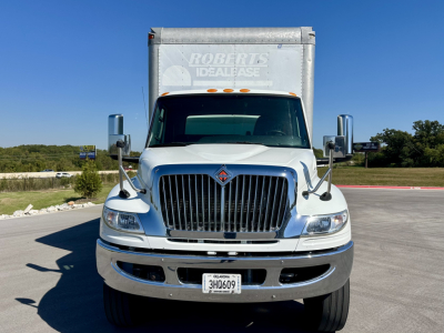 Truck front view showing 2023 International MV607 box truck with chrome grille and Roberts Ideal Lease box in background.