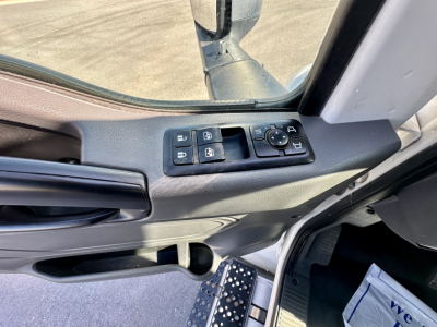 Truck interior door panel showing window control switches and mirror adjustment knob in driver-side door.