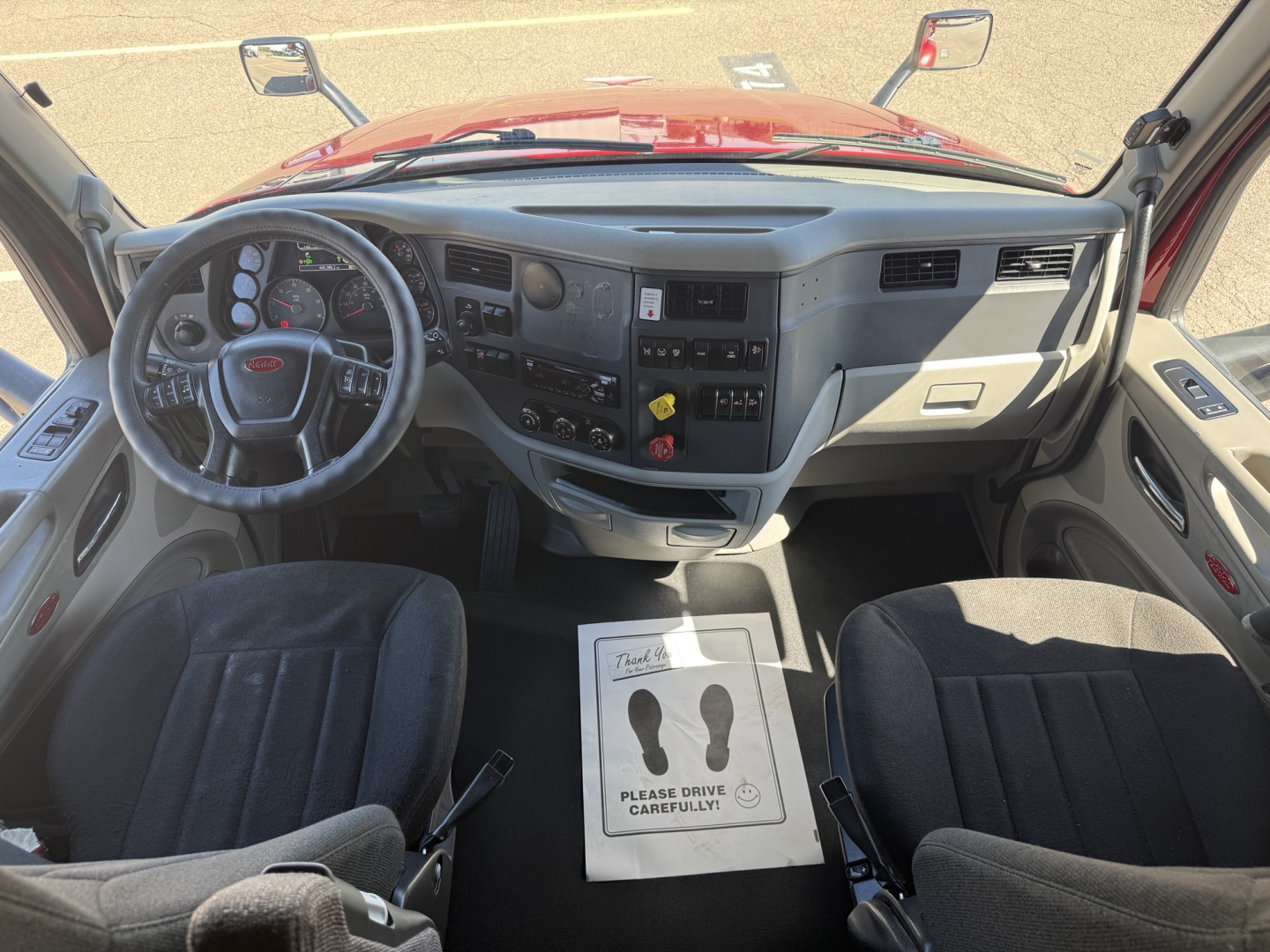 Peterbilt 579 cab interior showing steering wheel, instrument cluster, center console, and dashboard controls.