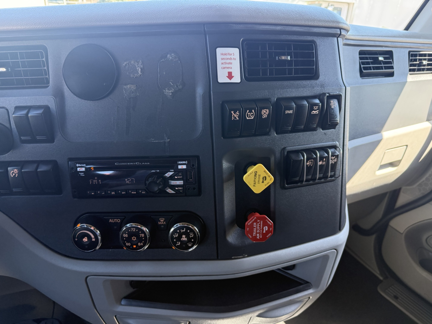 Peterbilt 579 truck dashboard panel and controls; visible switches, climate controls, radio head unit, ignition/gear area.