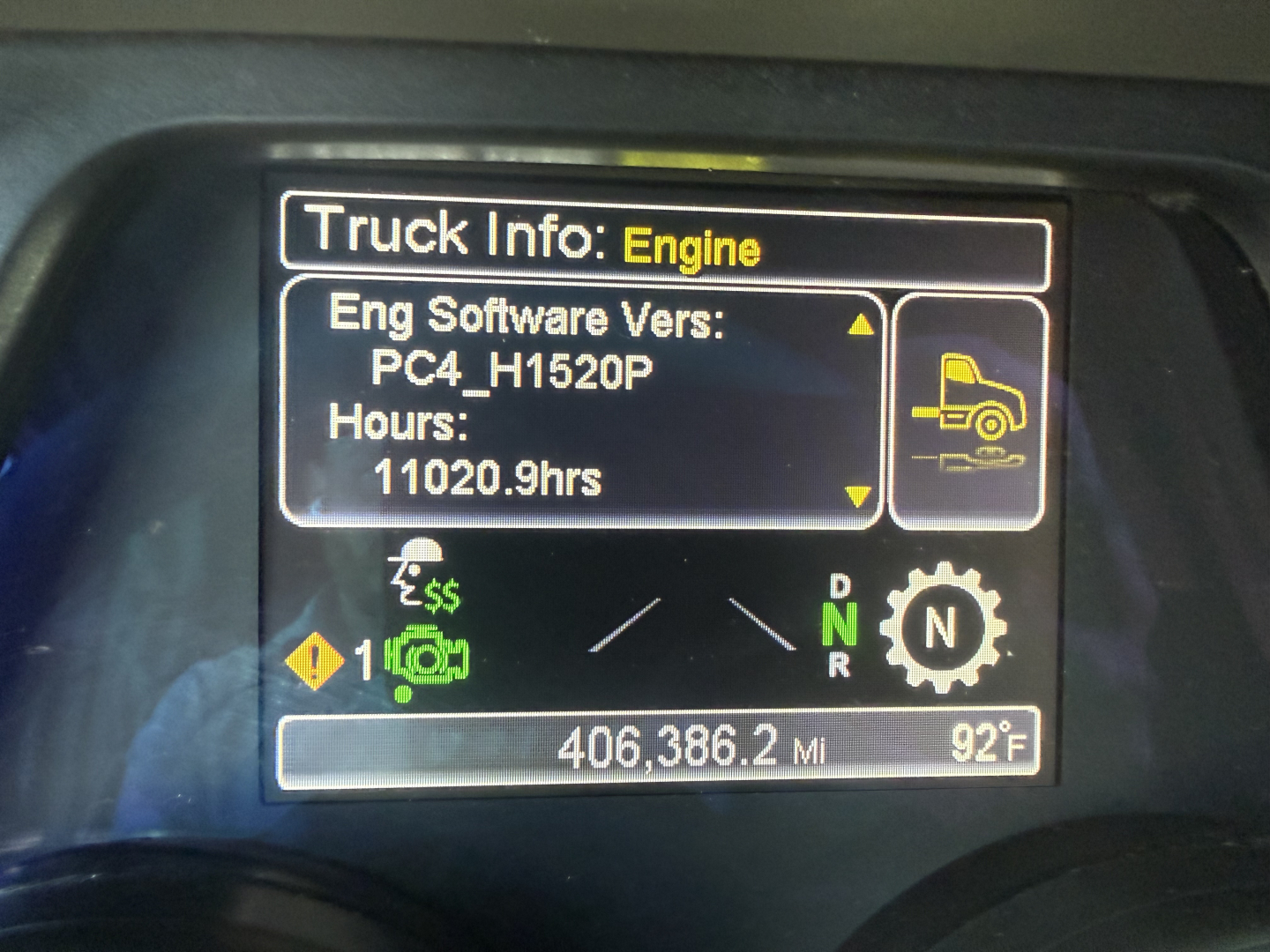 Truck info screen showing Engine software version PC4_H1520P, hours 11020.9, 406,386.2 miles, 92°F, gear selections N/D/R, warning icons, Peterbilt dashboard.