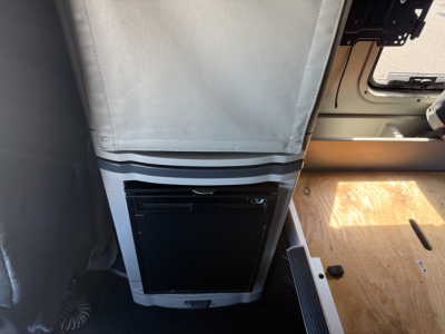 Peterbilt 579 cab interior with vertical luggage area and a black appliance panel near the floor; visible text shows stock and VIN information in listing context