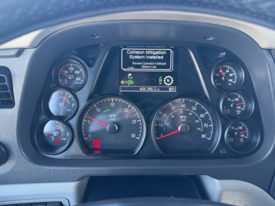 Peterbilt 579 dashboard showing instrument cluster and center display with warning about Collision Mitigation System Installed.