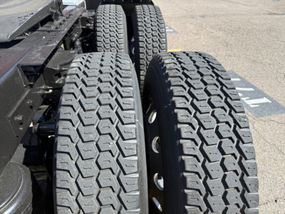 Truck rear dual tires with heavy tread on Peterbilt chassis showing dual wheel setup and frame components.