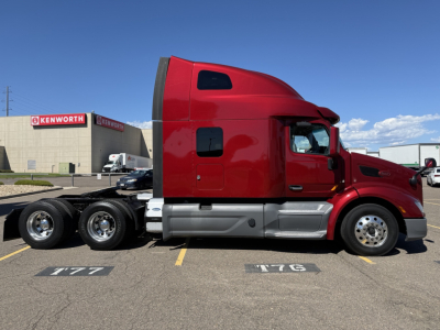 Peterbilt 579 semi truck side view showing red cab and dual rear axles.