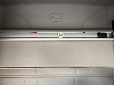 Peterbilt logo on a sleeper cab interior with a horizontal storage drawer and metal rails