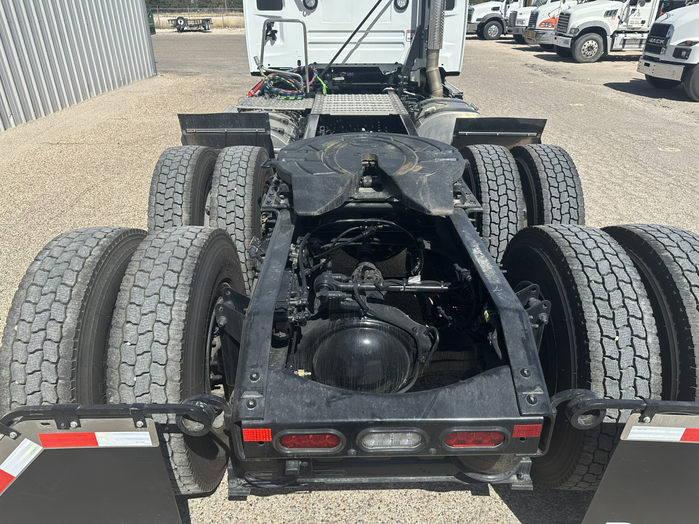 Truck chassis showing rear view of a Mack AN64T tractor with dual rear axles, multiple tires, and frame rails visible.