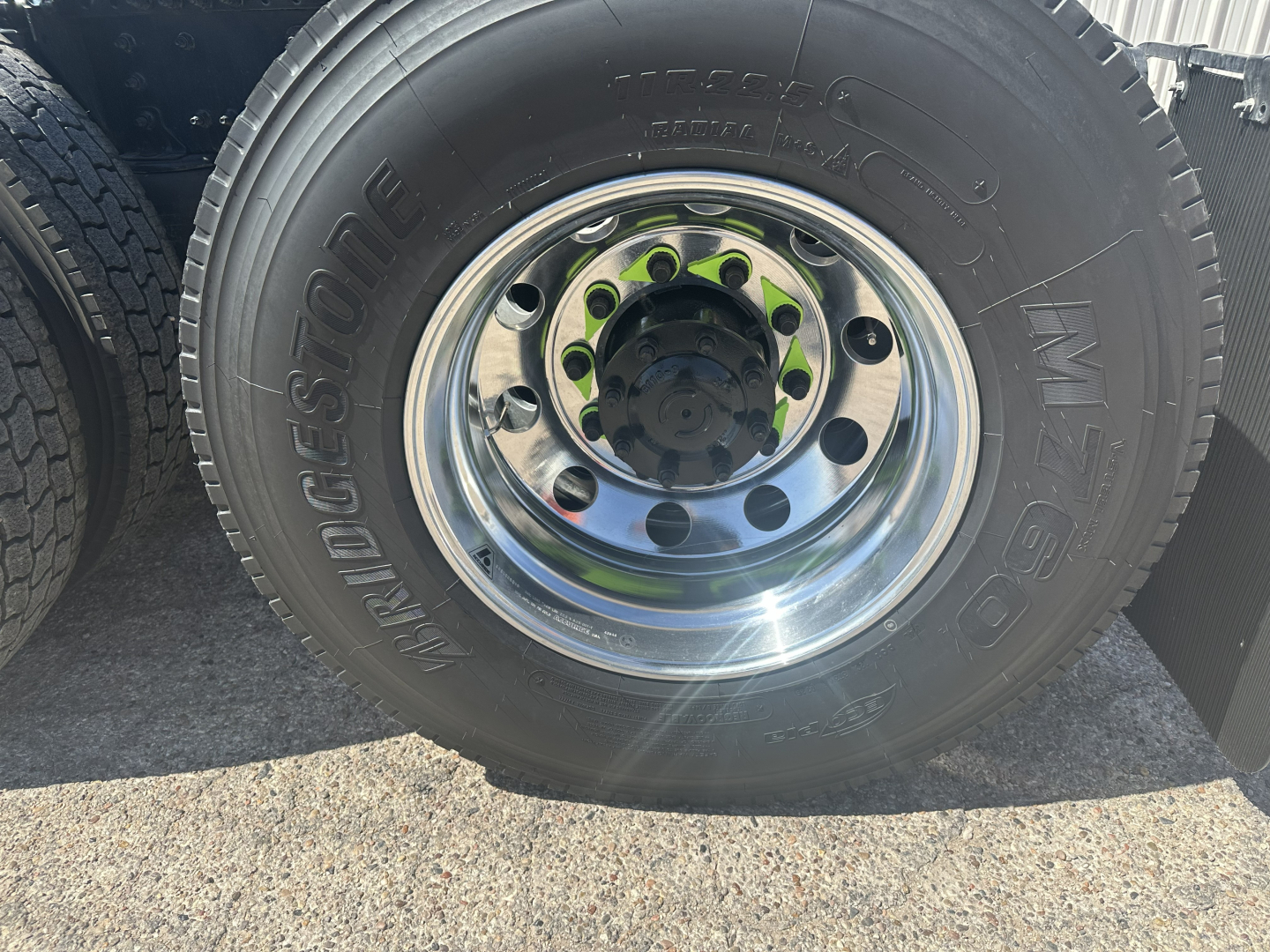 Wheel and tire close-up showing chrome rim and Bridgestone MT72 tire on Mack AN64T truck