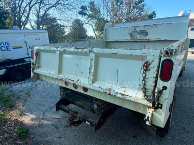 Dump truck bed of a 2008 Ford F550 rear view showing tailgate and hydraulic hoses with rust-free metal surfaces.