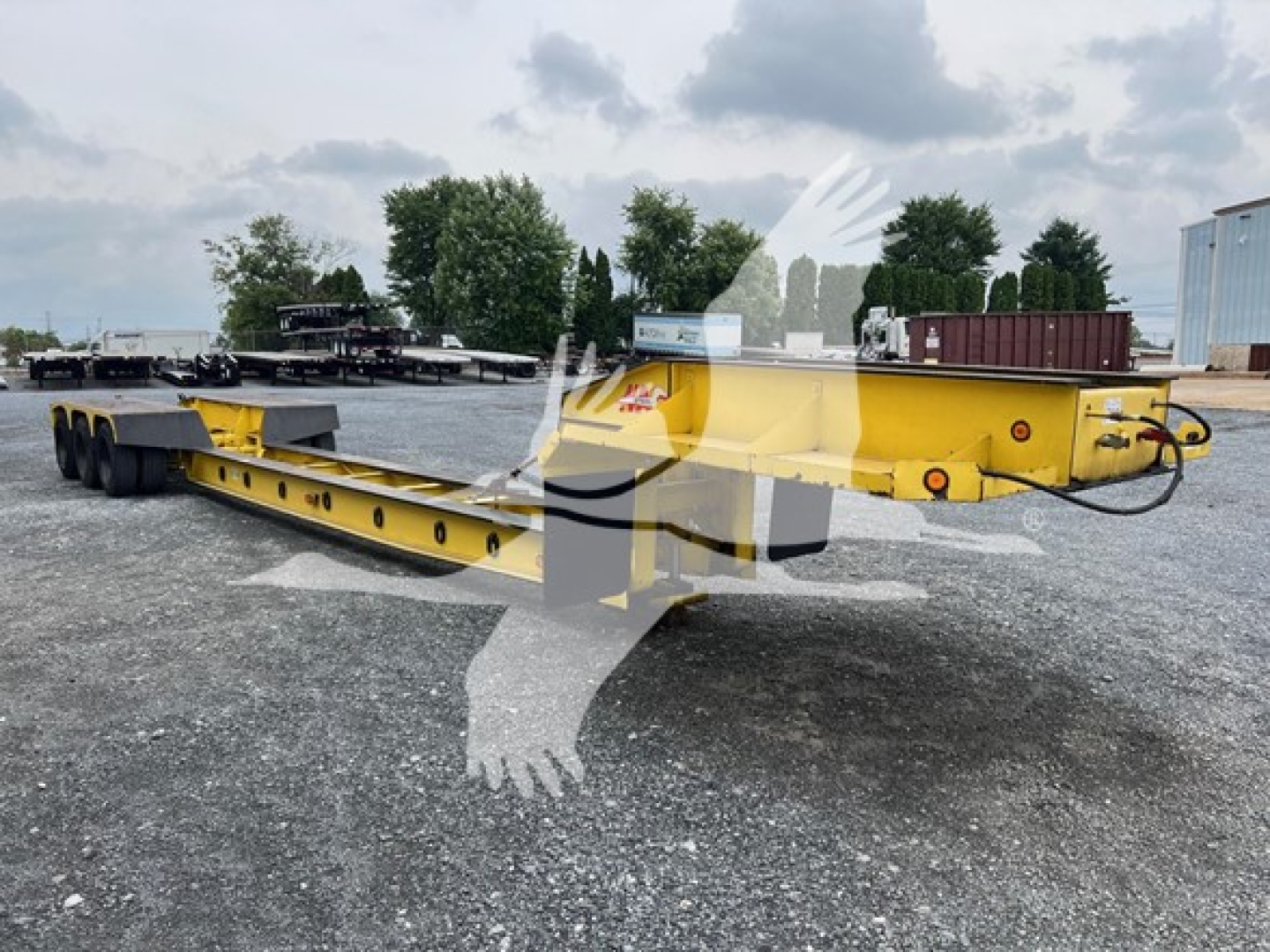 Used 1988 Rogers 50 Ton Beam lowboy trailer showing long yellow mainframe with multiple axles and gooseneck coupler.