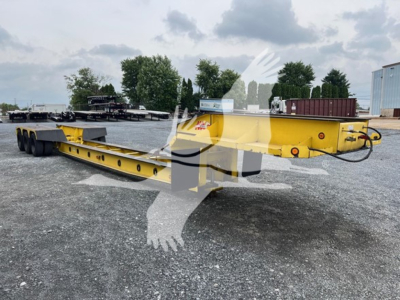 Used 1988 Rogers 50 Ton Beam lowboy trailer showing long yellow mainframe with multiple axles and gooseneck coupler.
