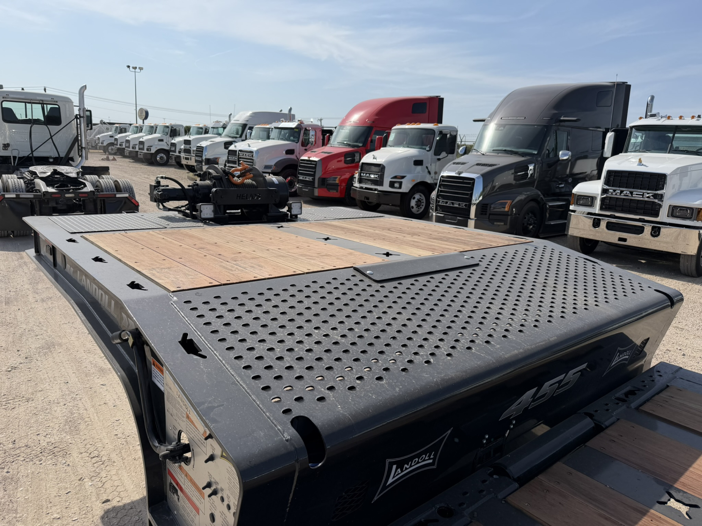 Landoll 455B-53 55 Ton traveling axle lowboy trailer deck with perforated steel and wood sections, in a dealership lot.