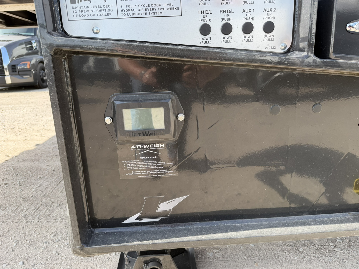 Landoll 455B-53 lowboy trailer control panel area showing air-weight scale and informational panels with labels.