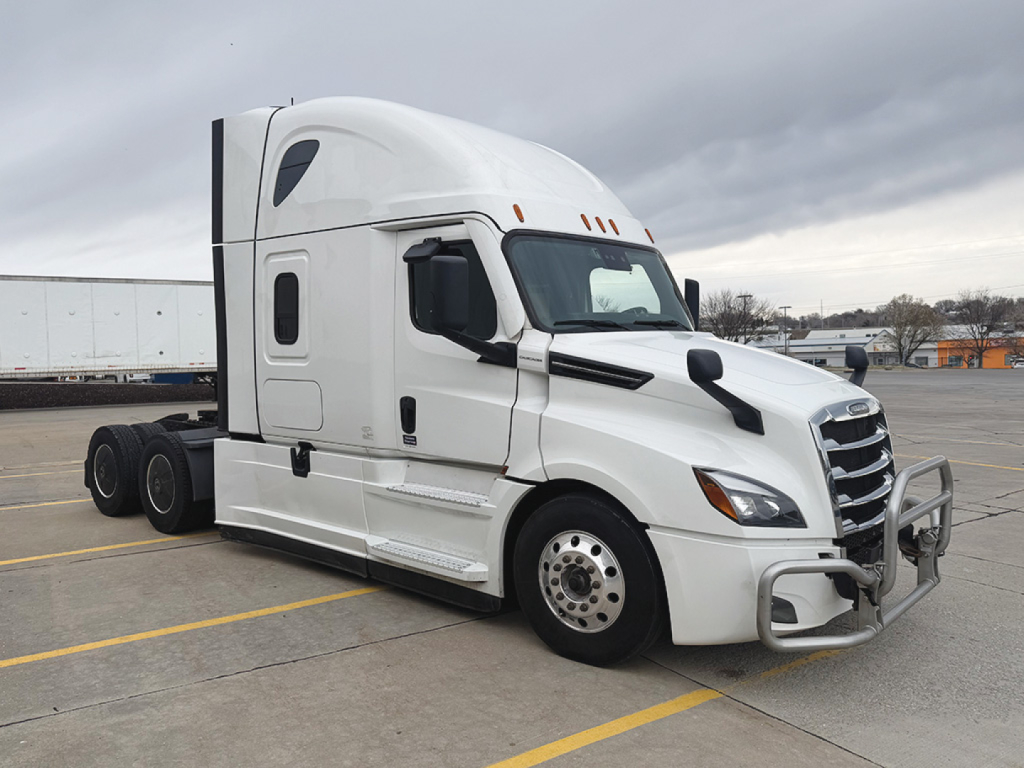 Truck cab side view showing 2023 Freightliner Cascadia126 with sleeper, front bumper guard, and dual rear axles.