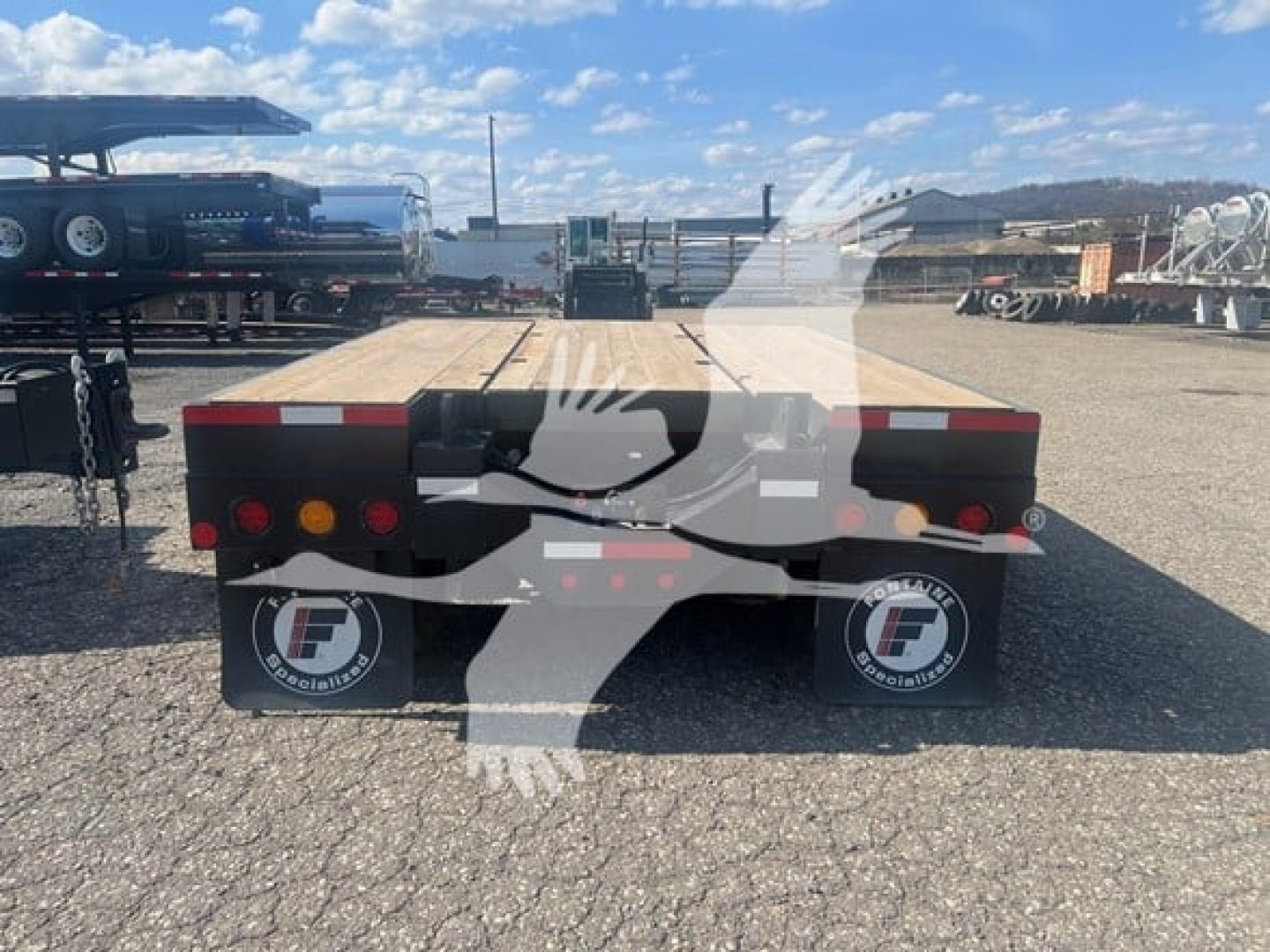 Fontaine paver lowboy trailer rear view showing dual mud flaps with Fontaine logo and red/amber taillights.