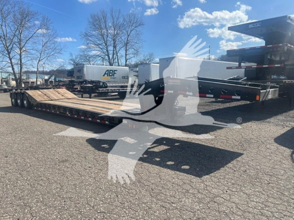 Fontaine lowboy trailer with flatbed loading ramp in an outdoor lot. Visible stickers and equipment in background.