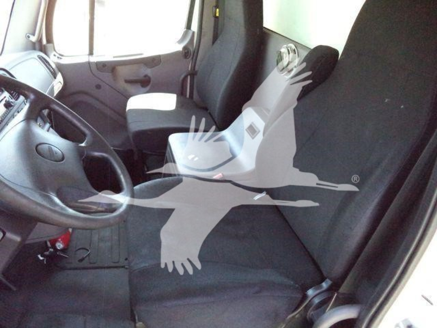 Vehicle interior showing driver seat and front passenger seat of a Freightliner M2 106 cab; no explicit text visible in cabin area.
