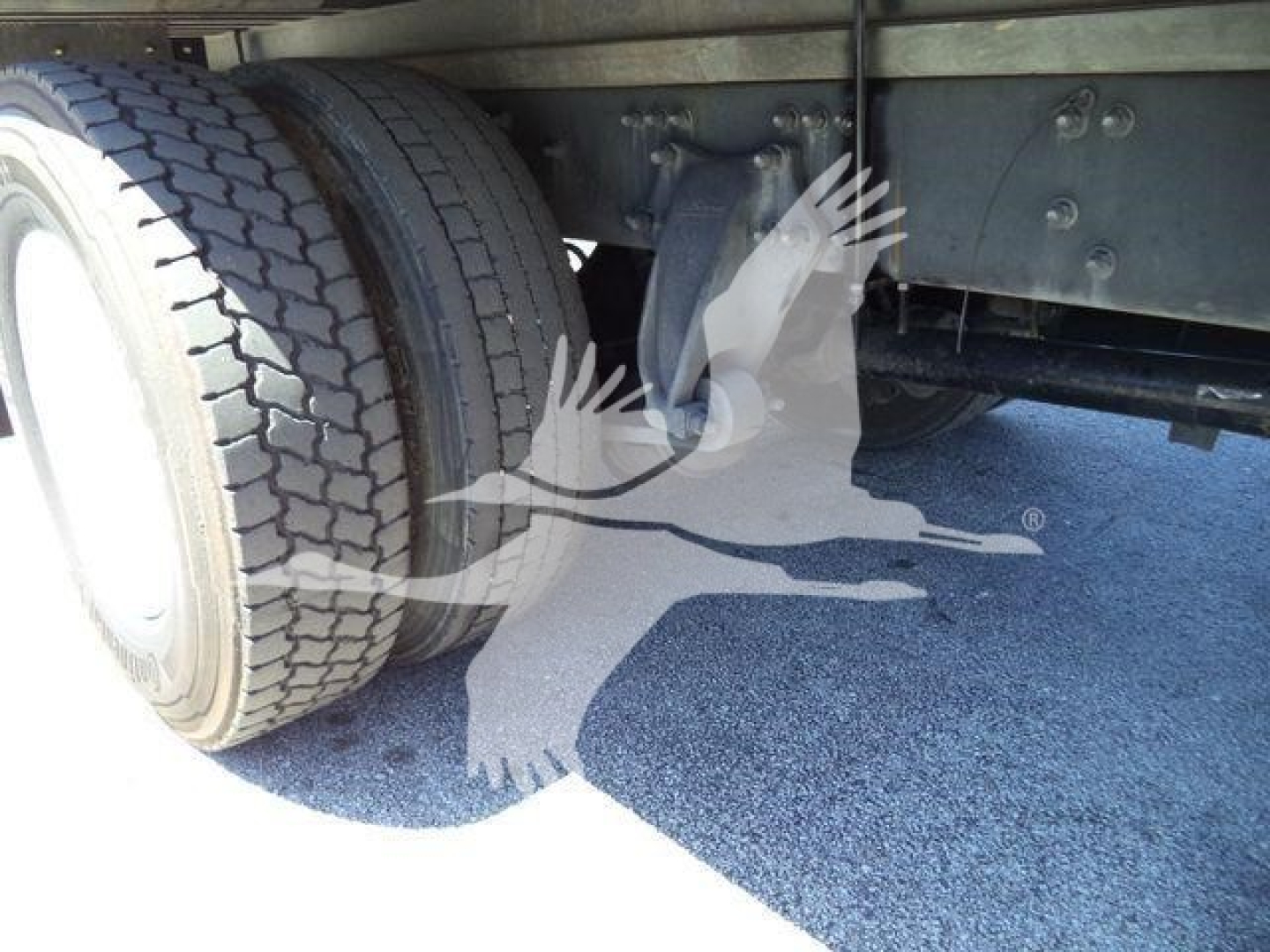 Truck rear dual wheels and undercarriage of a Freightliner M2 106 showing tires and suspension components.