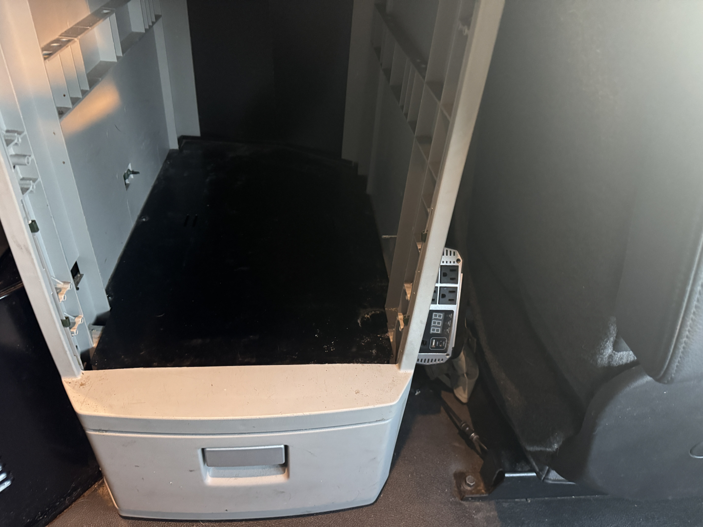 Kenworth T680 cab interior showing center console area and dash mounting with metal structure and control panel; empty storage area in center console