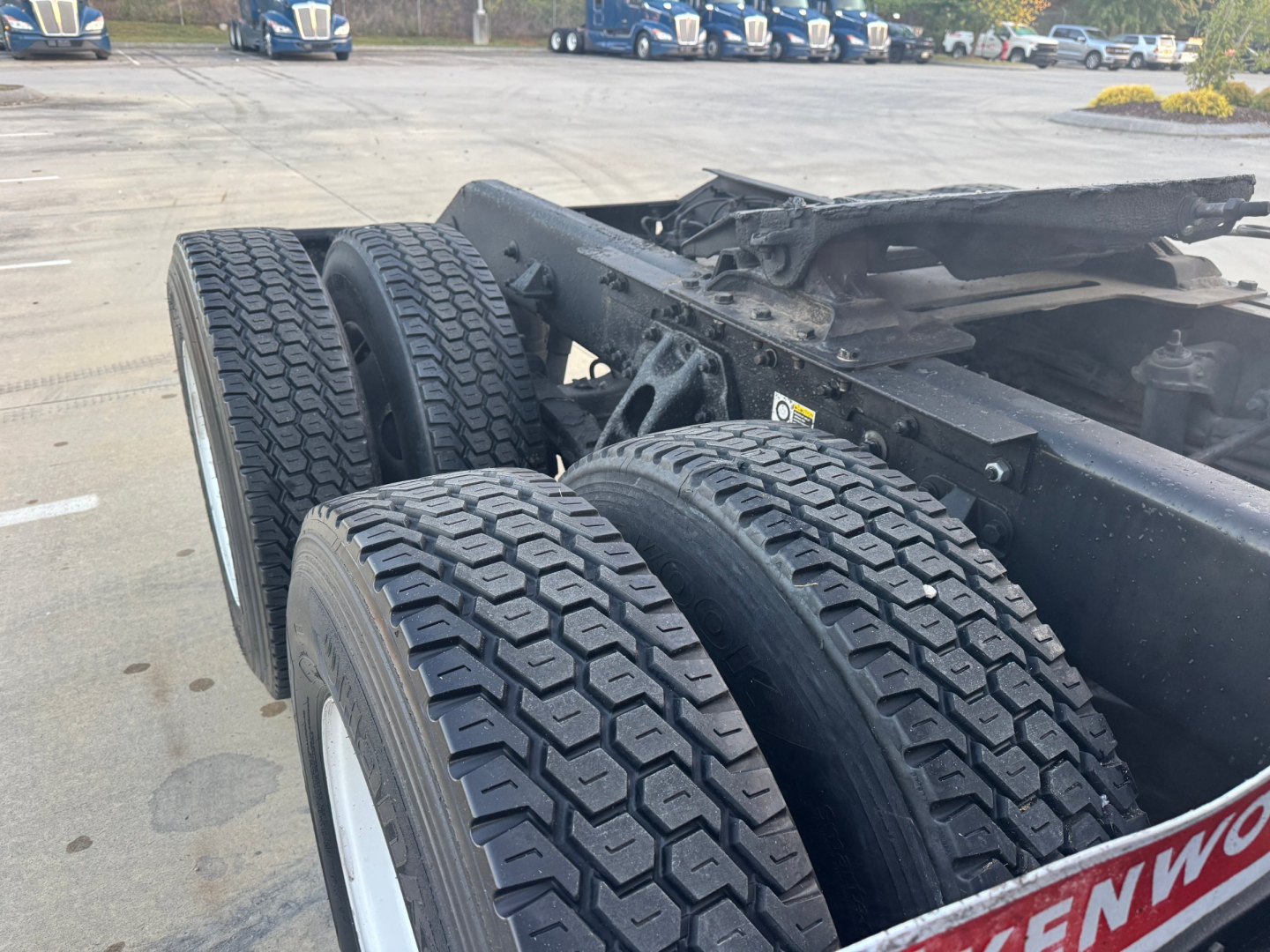 Kenworth T680 chassis with dual rear axles and dual tires in view, frame rail, and fifth wheel mounting area in the foreground.
