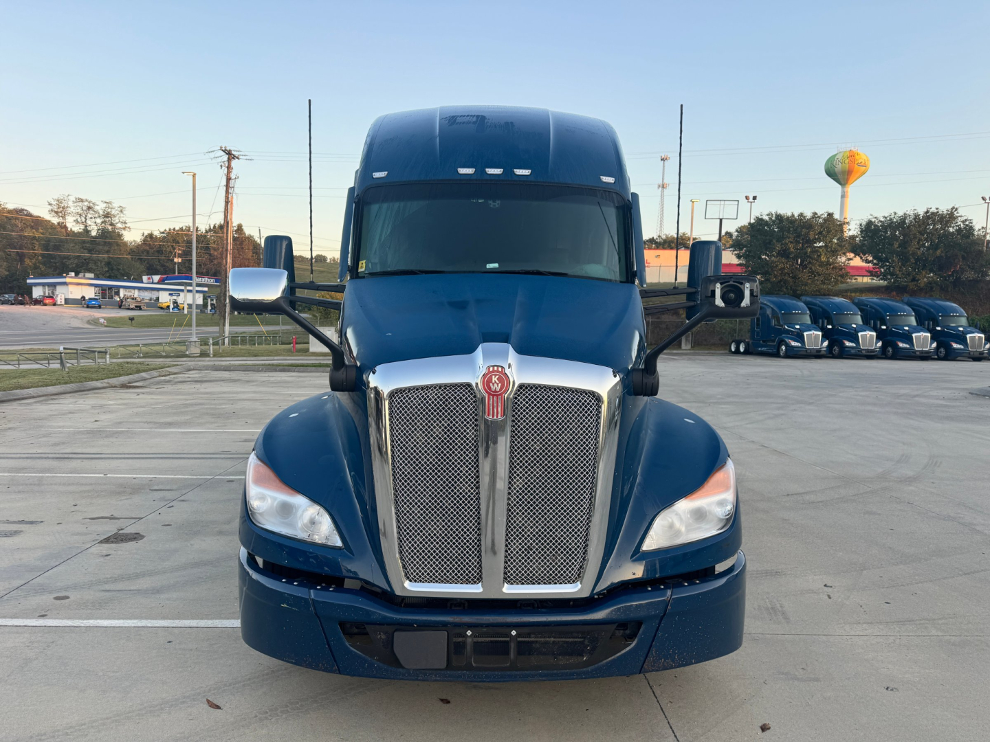 Kenworth T680 front view showing large chrome radiator grille and blue cab.