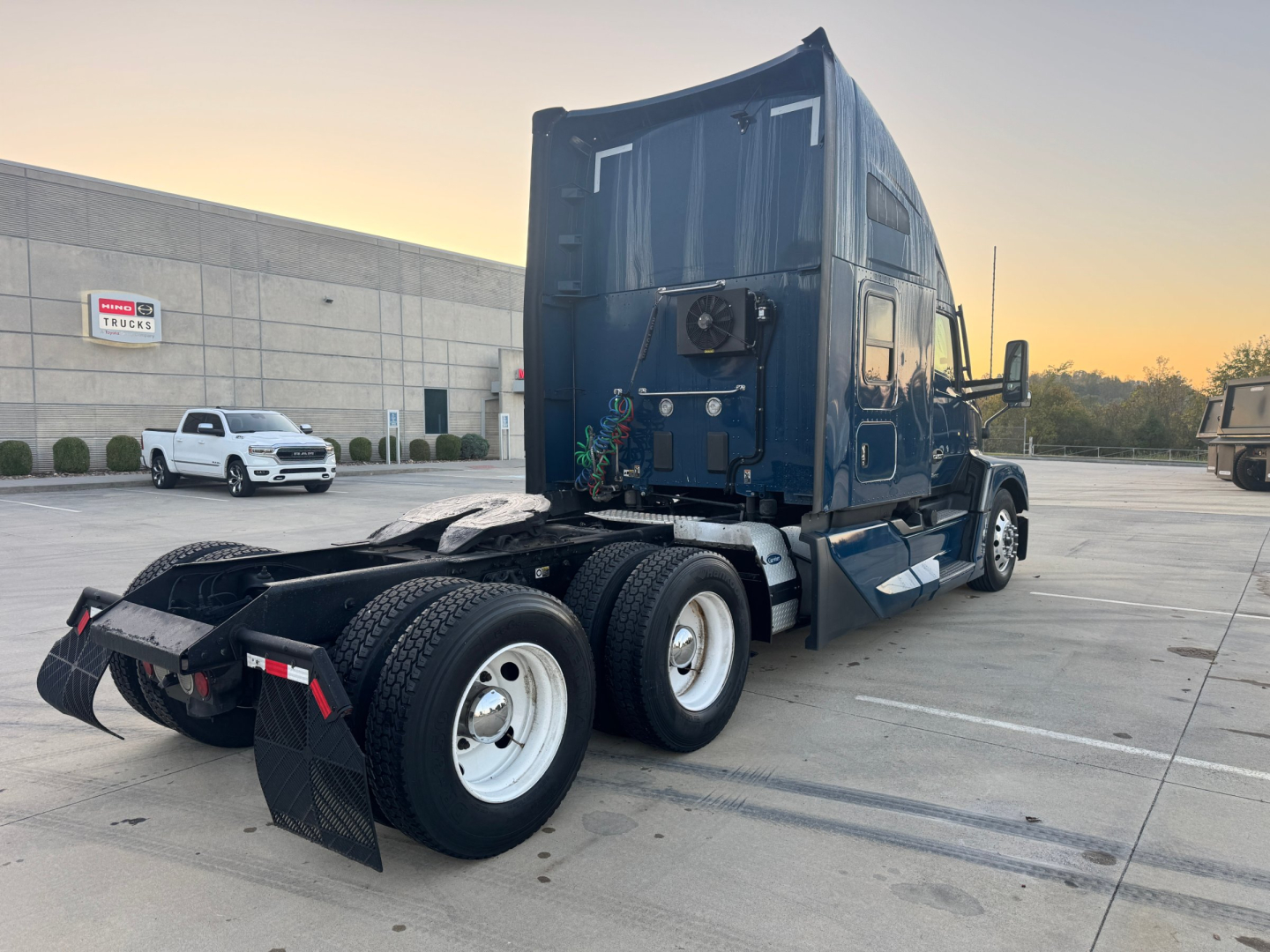 Kenworth T680 sleeper cab tractor rear view showing dual rear axles and fifth wheel, with blue exterior and fuel/air lines visible.