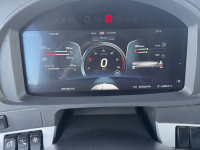 Digital instrument cluster display showing speedometer at 0 MPH, with trip data and fuel gauges in a Kenworth T680 cabin.