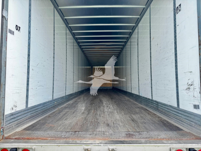 Great Dane plate van trailer interior showing empty cargo bay with wooden floor and white side walls, overhead ceiling beams.