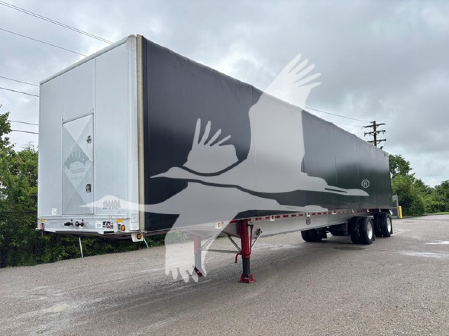 Trailer in-service view showing Curtainside trailer with white rear ramps and black side panels.