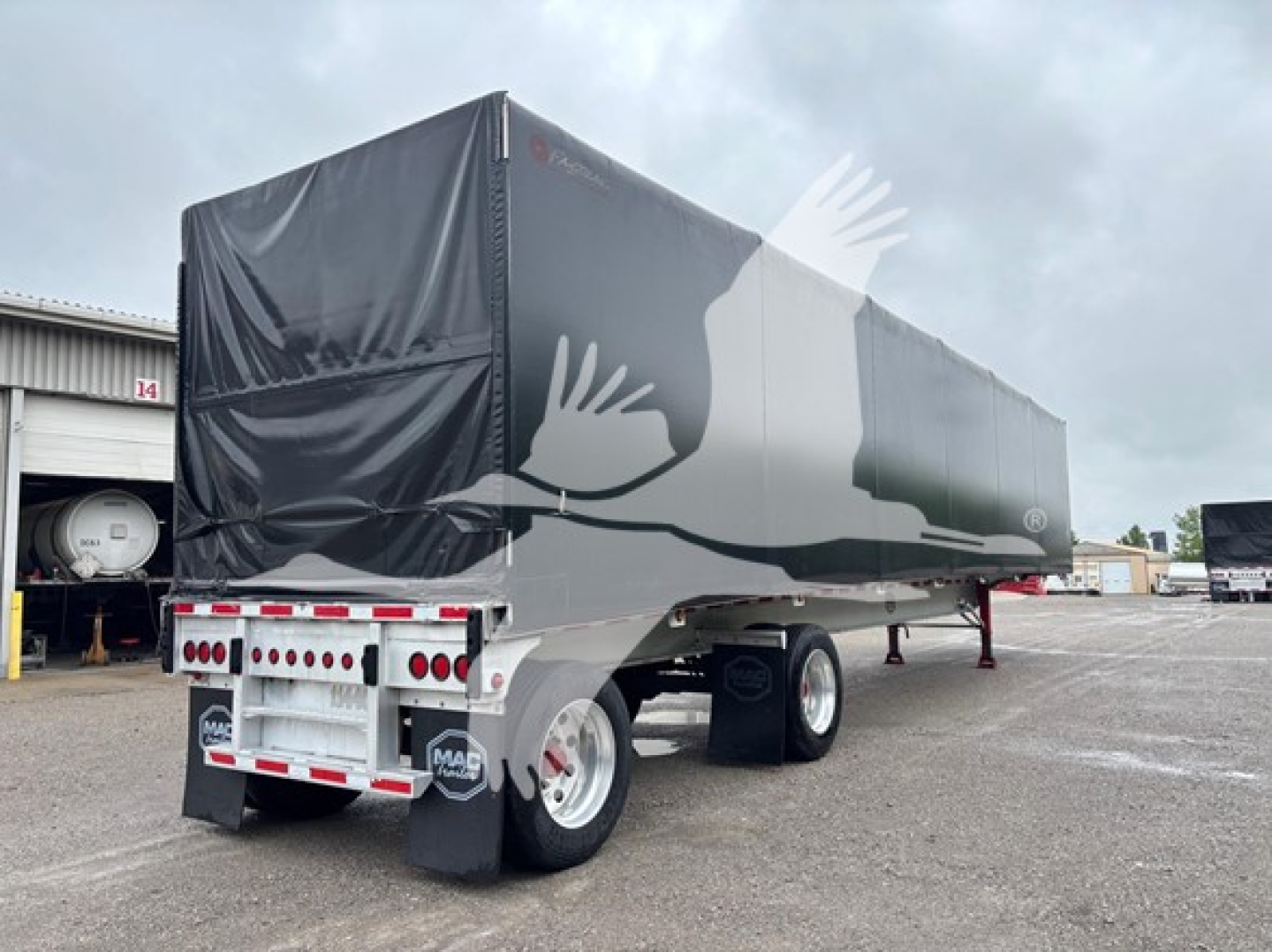 Mac trailer curtainside showing rear and side with tarp cover and dual rear axles.