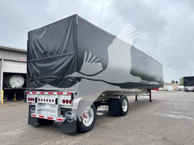 Mac trailer curtainside showing rear and side with tarp cover and dual rear axles.