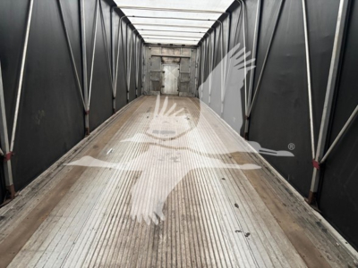 Trailers interior showing raised metal flooring and sidewalls with doorway at far end.