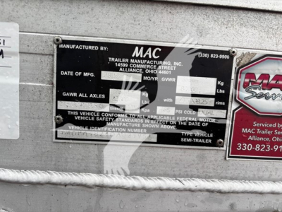MAC trailer identification plate mounted on a curtainside trailer with manufact. by MAC Trailer Manufacturing, serial and weight details visible in metal plate.
