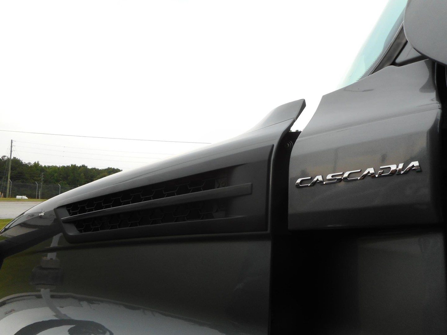 Freightliner Cascadia 126 truck cab side showing Cascadia badge and vented fender.