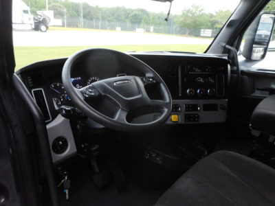 Truck cab interior showing steering wheel and dashboard of a 2022 Freightliner Cascadia 126 with instrumentation and control panel.
