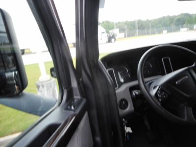 Truck cabin interior view of a Freightliner Cascadia 126 with steering wheel and dashboard visible.