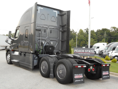 Freightliner Cascadia 126 sleeper cab side and rear showing dual rear axles and fifth wheel area with Freightliner truck dealership signage