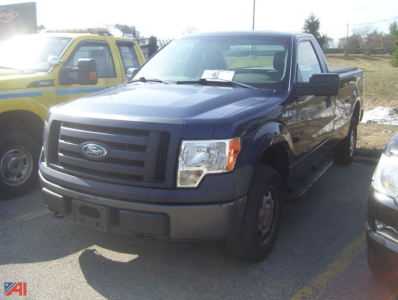 Ford F-150 pickup truck in blue, front-left view, with black bumper and grille, 2011 model, parked next to a yellow vehicle.