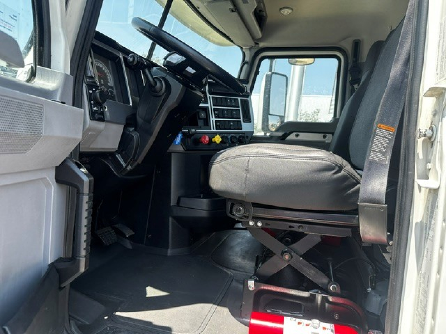 Interior of a 2020 Mack Anthem truck cab showing driver seat, steering wheel, dashboard controls, and entry to the cab.