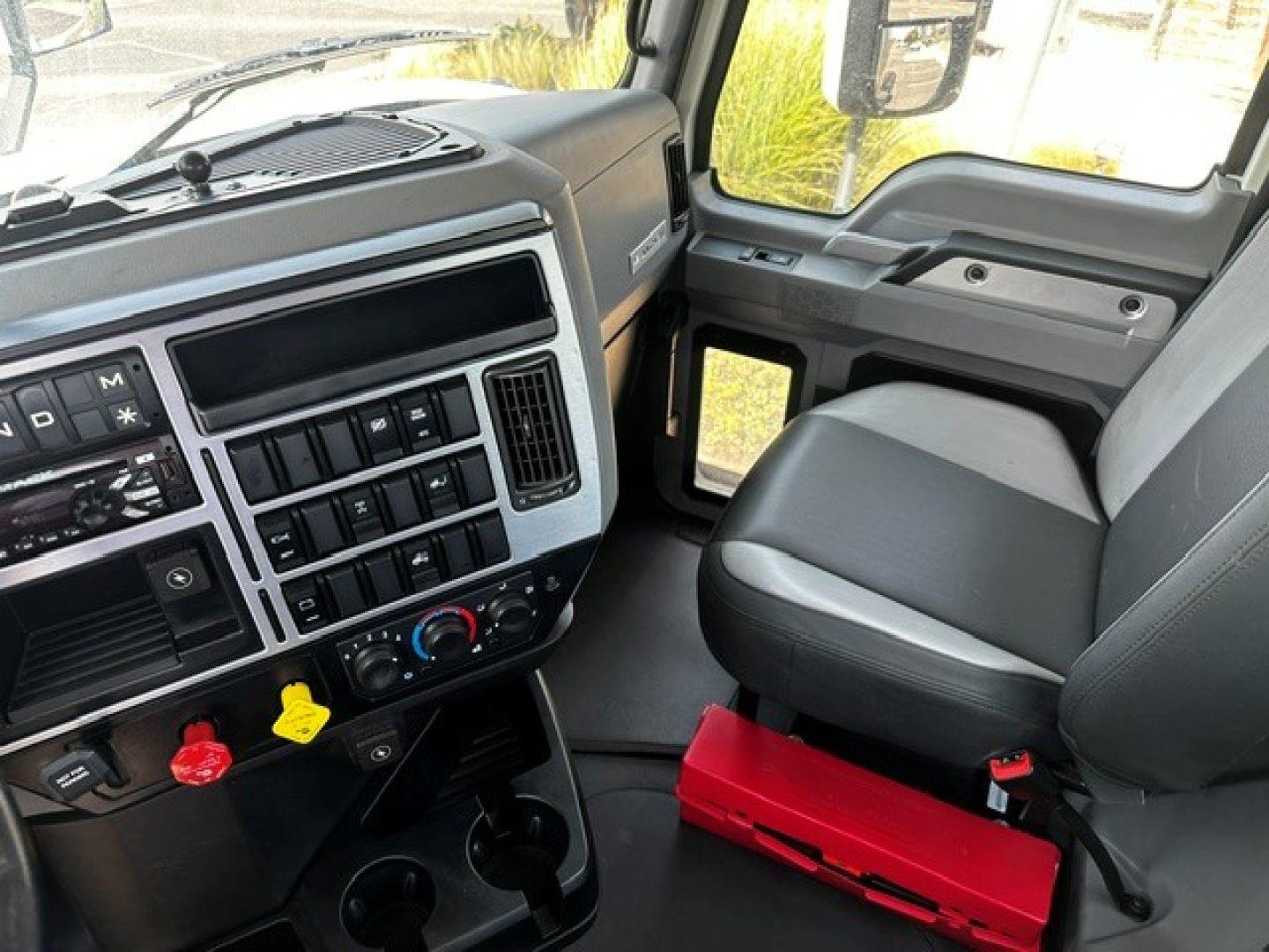 Dashboard and driver seat area of a 2020 Mack Anthem truck cabin showing steering column, center console, and gear controls.