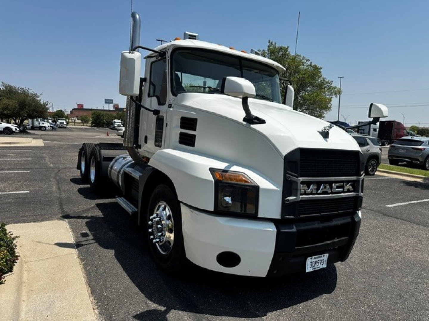 White 2020 Mack Anthem conventional daycab truck in a parking lot, front three-quarter view. Visible text includes MACK on the grille and a license plate at the front bumper. No other legible labels or numbers visible.