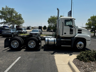 Side view of a white 2020 Mack Anthem conventional daycab truck tractor showing the cab, fuel tanks, and rear axles; no visible textual labels or logos legible.