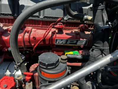 Engine bay with red valve cover showing MP8 badge, black oil cap, orange ring cap, red hoses, and surrounding components.