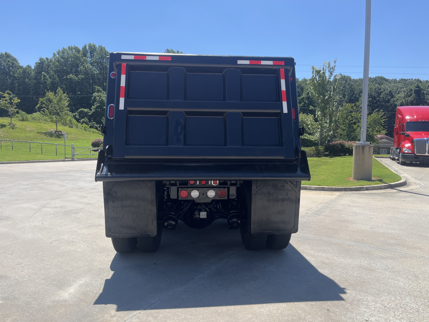 Kenworth dump truck rear view showing dump bed and rear axle assembly.