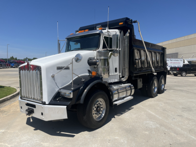 Kenworth T800 dump truck in white cab with black dump bed, side view showing large chrome grille, dual exhaust stacks, step plates, and Fuel/Tank area.