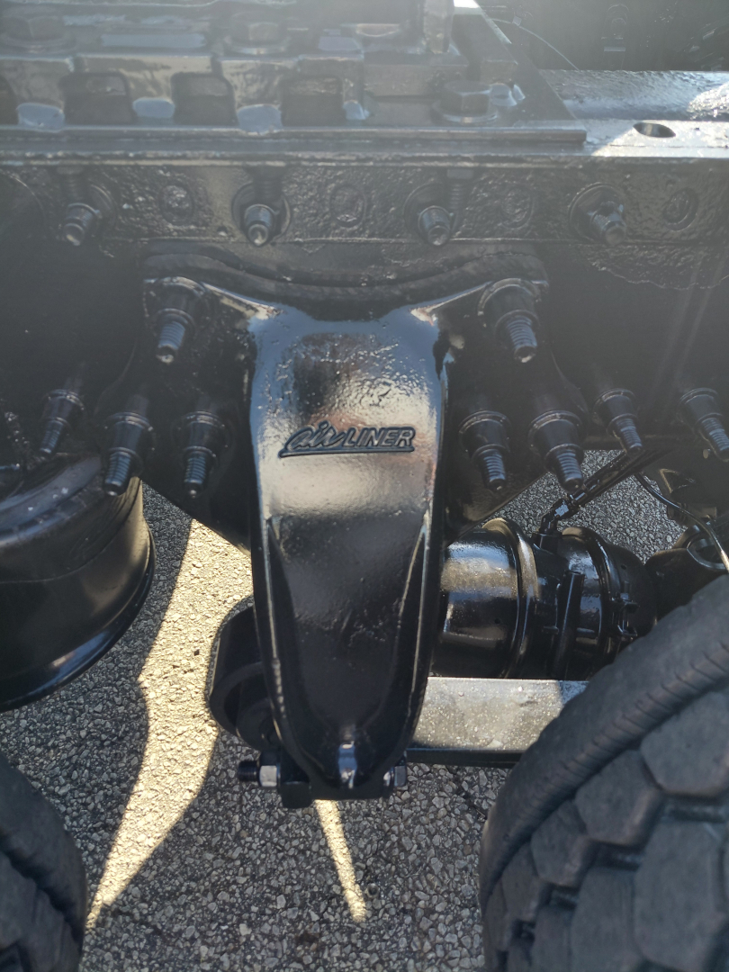 Rear view of Freightliner PT126064S suspension and driveshaft with Dana/Allison HPM steering component visible; close-up of center axle hanger and bolts.