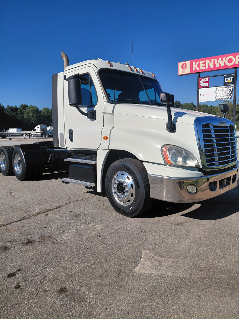 Truck cab and front of a Freightliner PT126064S conventional sleeper tractor showing large grille and side mirrors.